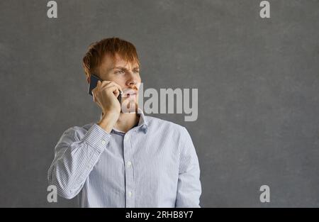 Young man talking on his mobile phone with an angry and troubled face expression Stock Photo