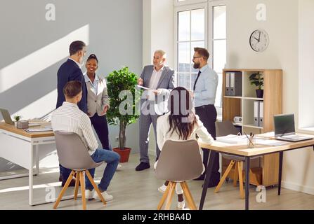 Diverse office coworkers talking and smiling during meeting in office Stock Photo
