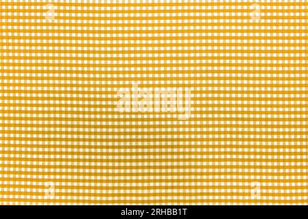 The texture of linen fabric in a large cell of yellow and white. Scottish tailoring material. checkered fabric Stock Photo