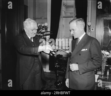 Washington, D.C.:   February 17, 1938  Vice President Garner playfully tries his 'stickup' technique on Senator Harry Truman of Missouri, present owner of the .45 pistols that were formerly used by Jesse James. Senator Truman secured the guns in Southern Missouri from a doctor's wife, whose husband received them in payment of medical services rendered to Frank James, another of the James' boys. Jesse James had previously left them to Frank after he was killed by the Pinkerton men. The bandit garnered nearly $1,000,000 in a series of holdups with the guns. Stock Photo