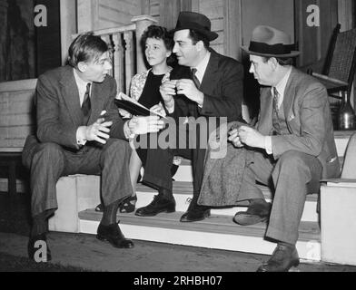 New York, New York:  1941 From L-R, male lead Walter Huston, heroine Jessie Royce Landis, author William Saroyan and producer Eddie Dowling discuss Saroyan's play, 'Love's Old Sweet Song'. Stock Photo