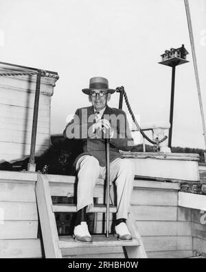 Kennebunkport, Maine:  July 29, 1939 Pulitzer Prize winning novelist and dramatist Booth Tarkington on his 70th birthday sitting his boat with his dog 'Figaro'. Stock Photo