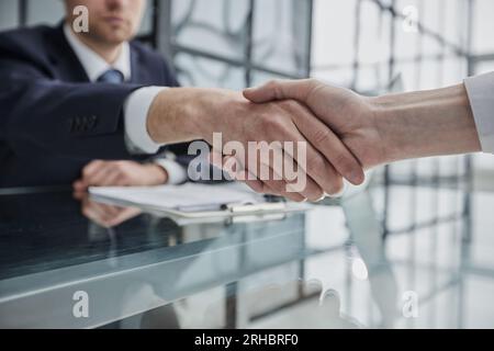 Double up on manpower to make it happen. two businessmen shaking hands during a meeting in a modern office. Stock Photo