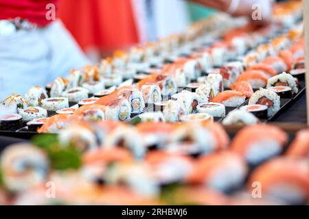 Rows of assorted palatable sushi with fish placed on stall in Asian buffet Stock Photo