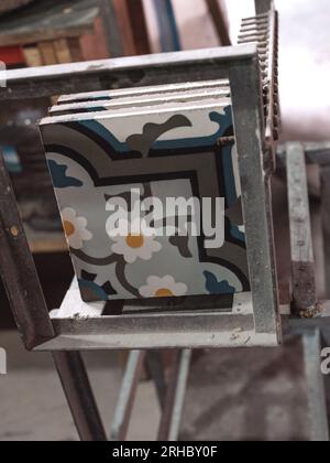 Handmade stylish designed geometric ceramic tiles with colorful ornaments placed on metal framed construction of stencil in workshop Stock Photo