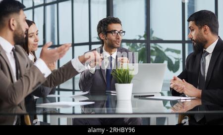 Glad to be part of the creative team. Group of cheerful business people sitting together at the table and discussing something Stock Photo