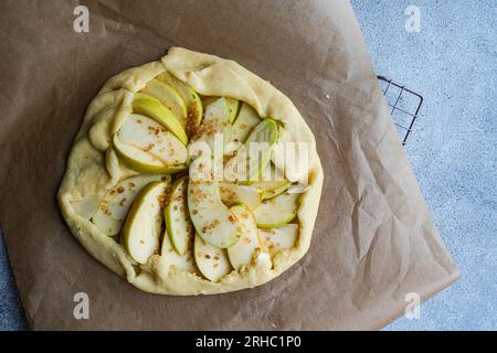 Overhead view of a raw homemade apple galette on parchment paper Stock Photo