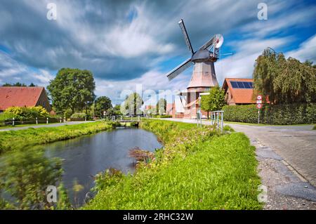 Windmill by a canal in summer, Warsingsfehn, East Frisia, Lower Saxony, Germany Stock Photo