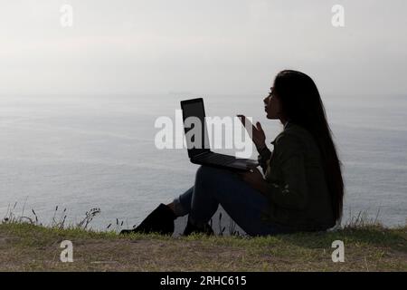 Paradise: Beautiful Woman Engaged in a Virtual Meeting Amidst Beachside Tranquility Stock Photo