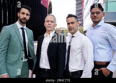 Team portrait various male professionals confidently posing outside business center. Group serious. Stock Photo