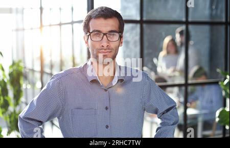 Young businessman in casual clothes stands with his hands on his waist Stock Photo