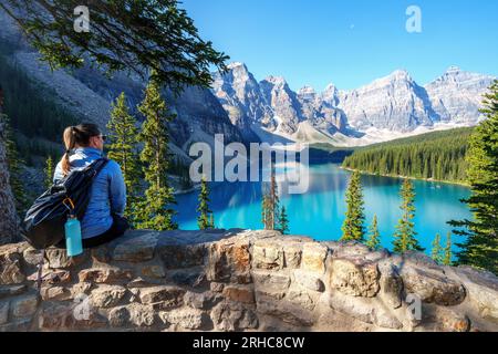 Female Hiker enjoying the Views over Moraine Lake during summer morning in  Banff National Park, Canadian Rockies, Alberta, Canada.  Banff National Pa Stock Photo
