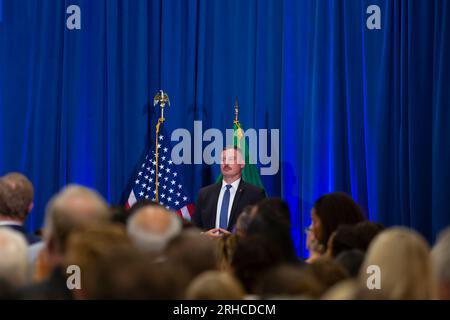 Seattle, Washington, USA. 15th August, 2023. A member of the Secret Service stands vigil at an event celebrating the one-year anniversary of the Inflation Reduction Act being signed into law at McKinstry, a green energy construction company, in the Industrial District of Seattle. Credit: Paul Christian Gordon/Alamy Live News Stock Photo