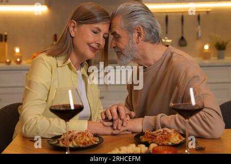 Affectionate senior couple having romantic dinner at home Stock Photo