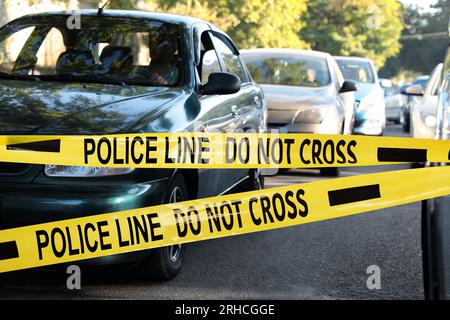 Yellow crime scene tape blocking way on street Stock Photo