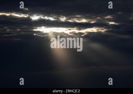 Sun rays through the clouds in the sky. The sun shines through the clouds. Stock Photo