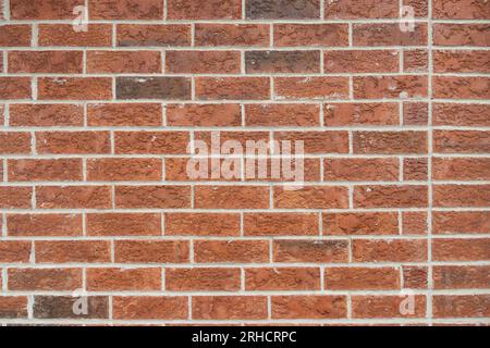 Red and brown bricks in horizontal pattern - close-up of wall - different sizes and shapes of bricks - white mortar between bricks Stock Photo