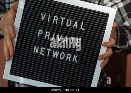 Female hand holding Letter board with text of VIRTUAL PRIVATE NETWORK VPN creation Internet protocols for protection private network anonymous safe and secure internet access on gadgets. Future technologies  Stock Photo