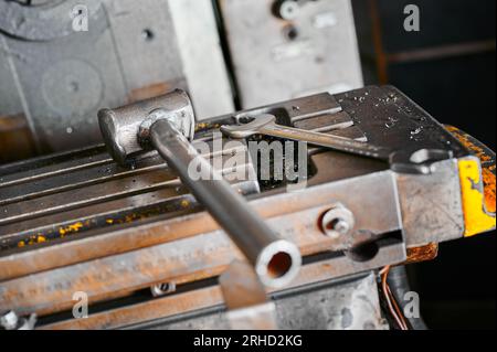 Metal hammer and wrench on lathe machine tool slide in shop Stock Photo
