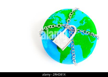 Globe trapped in chains and secured with a padlock isolated on white background. Visual metaphor for the need to break free from all constraints and w Stock Photo
