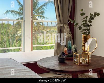 Glass vase with with eucalyptus leaves, jewelry box and incense stick on the coffee table in the living room near window Stock Photo