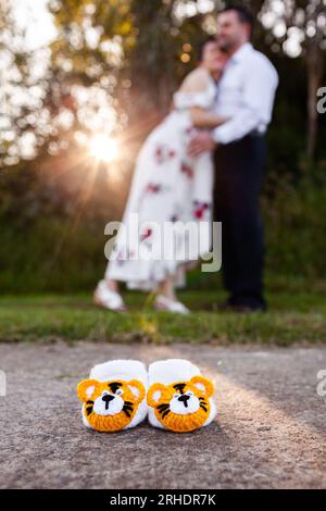 Year of the tiger baby boots with pregnant mother in background Stock Photo