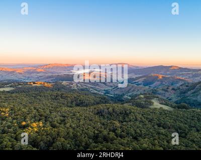 Sunset dusk view over Hunter valley region with lake St Clair nestled amongst hills and the last light of the day on distant hilltops under clear sky Stock Photo