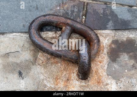 Close-up of an old, rusty mooring ring on the stone dock in the harbor, Savona, Liguria, Italy Stock Photo