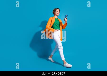 Full body size cadre of young optimistic project manager nice woman student communicating phone chat isolated on blue color background Stock Photo