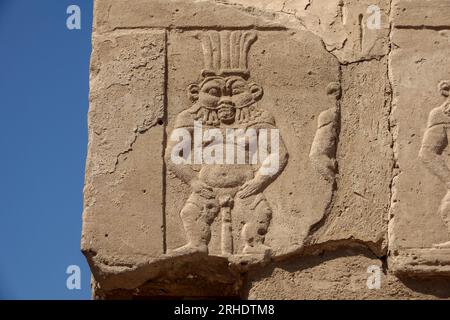 Carving of god Bes In the outer courtyard at Denderah Temple, near Qena, Egypt Stock Photo