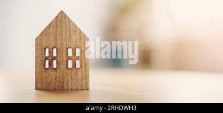 Figurine of wooden house standing on the table indoors. Stock Photo