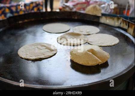 High angle of fresh dough placed on big metal baking pan on street in Mexico while preparing tasty chapati flatbread Stock Photo