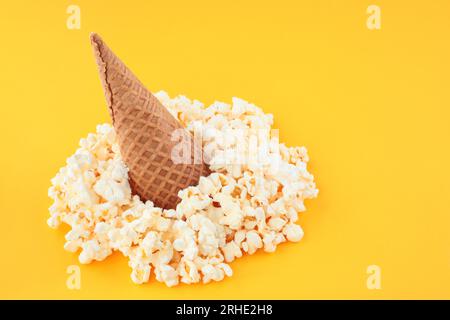 Waffle Cone with Salted Popcorn on yellow background. Snack concept close-up Stock Photo