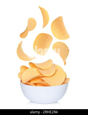 Levitating potato chips, falling to white bowl on white background close-up Stock Photo