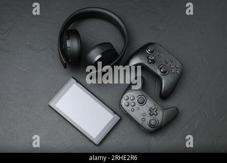 Black devices: gamepads, headset and tablet pc. Gaming concept on black background close-up Stock Photo