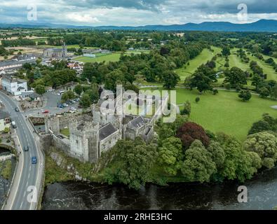 Aerial view of Cahir castle and town in Ireland with Tower House, outer castle, circular, rectangular towers, banquette hall, guarding the crossing Stock Photo