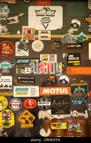 India, Ladakh, Nubra Valley, Tirit, motorcycle group stickers on village cafe window Stock Photo