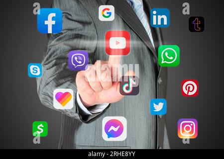 Man pushes virtual social media app icon on a dark background, connection to social media concept Stock Photo