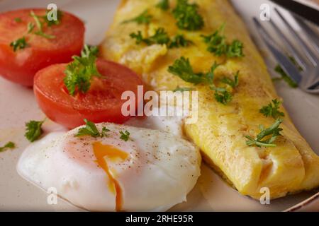 Haddock fillet with tomatoes and poached egg and garnished with parsley. Stock Photo