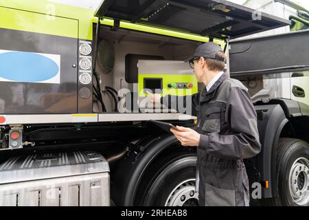 Worker with digital tablet operating construction machine equipment. Stock Photo