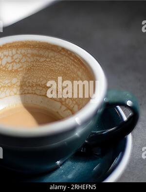 empty coffee cup, patterns on coffee ceramic, on concrete table and green ceramic cup Stock Photo