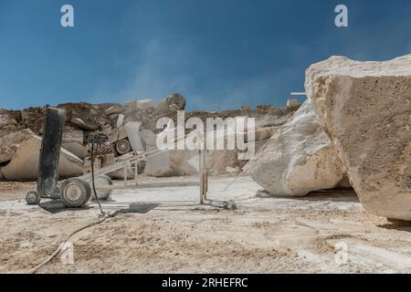 beautiful and artistic photograph of a marble mine. including men working with heavy machinery Stock Photo