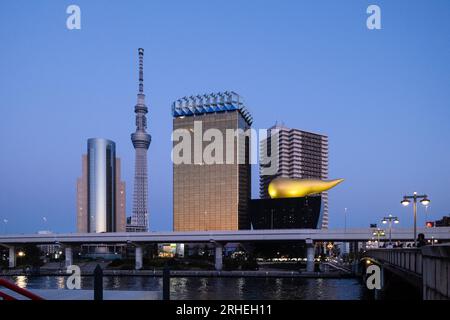 View of Tokyo Skytree and The Asahi Beer Hall (a.k.a. Super Dry Hall, or Flamme d'Or) from Asakusa, across the Sumida River, Tokyo, Japan, at twilight Stock Photo