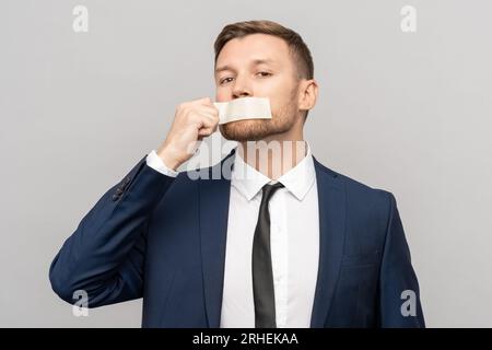 Man office worker with tape on his mouth. Prohibitions of expression opinion, freedom of speech Stock Photo