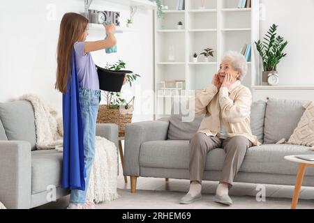 Little magician showing trick to her grandmother at home Stock Photo