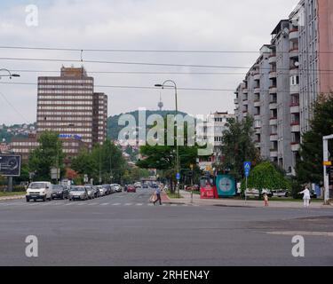 Street known as Sniper Alley during Bosnian War with TV aka Broadcasting Tower on hill. Sarajevo, Bosnia and Herzegovina, August 16,2023. Stock Photo