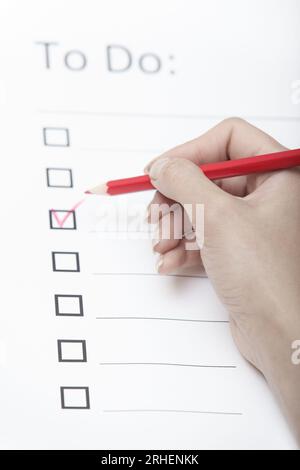 Human hand writing on a checklist document Stock Photo