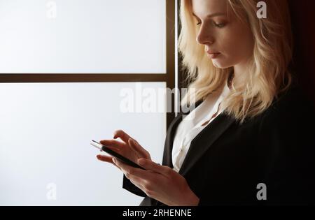 Young adult woman using smartphone at the office Stock Photo
