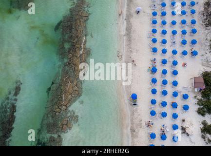 Drone aerial of tropical sandy beach holiday resort with beach umbrellas and people swimming and relaxing. Summer vacations. Landa beach Ayia Napa Cyp Stock Photo