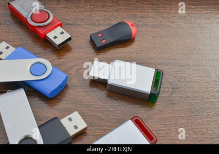 Closeup of several USB sticks on the wooden table. Several different USB sticks. Flash drives representing mobile storage and advanced technology. Stock Photo